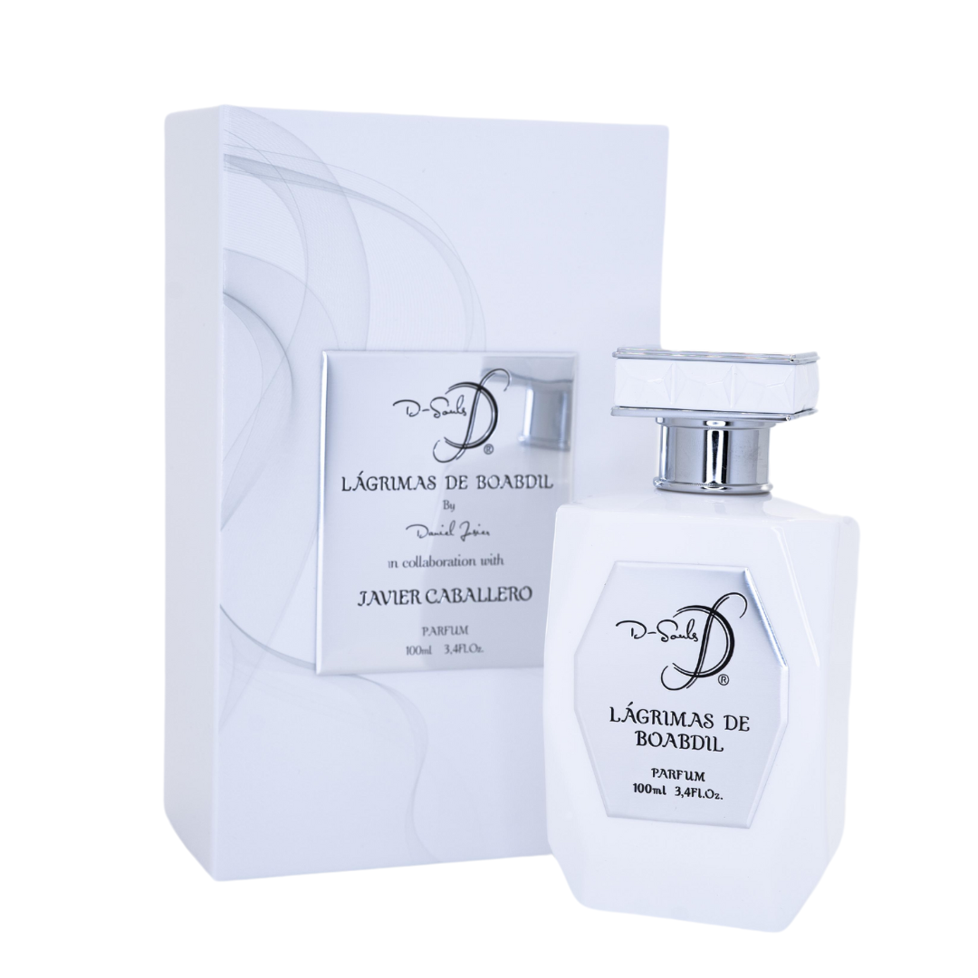 El frasco, de líneas geométricas limpias y un acabado en un blanco brillante inmaculado, cuenta con una placa frontal metálica de tono plateado que resalta el nombre de la fragancia: "Lágrimas de Boabdil", así como la mención al reconocido perfumista Daniel Josier y a la colaboración con Javier Caballero. El tapón, también blanco con detalles facetados y acentos plateados, armoniza con el resto del conjunto y refuerza la imagen de elegancia y lujo contemporáneo.
La caja que lo envuelve continúa con esta e