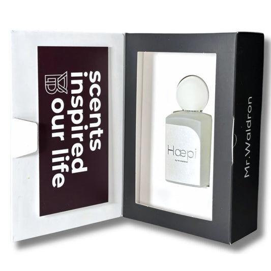 Perfume "Haepi" de Mr. Waldron en su estuche original. Caja con ventana que deja ver el frasco minimalista y mensaje “Scents inspired our life”. Disponible en Perfumería Sanchotena.