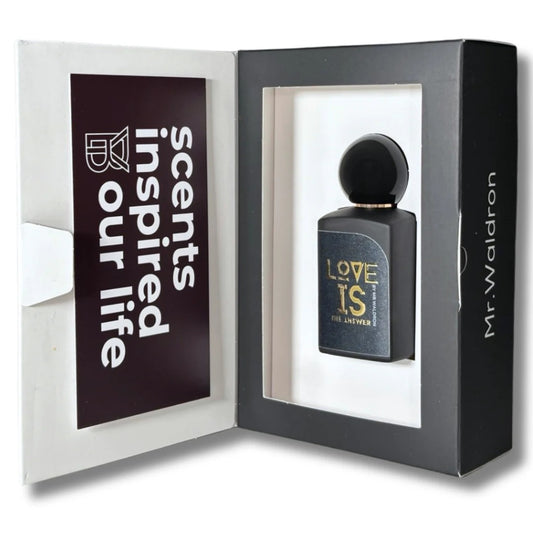 Estuche del perfume "Love Is the Answer" de Mr. Waldron, con diseño sofisticado y ventana que revela el frasco negro con letras doradas. Lema “Scents inspired our life”. Disponible en Perfumería Sanchotena.