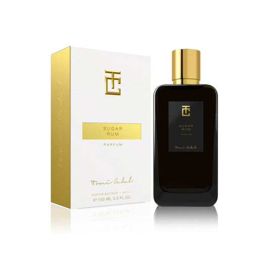 Perfume ‘Sugar Rum Parfum’ de Toni Cabal, en frasco negro con tapón dorado y caja blanca con detalles dorados, destacando notas dulces y especiadas.