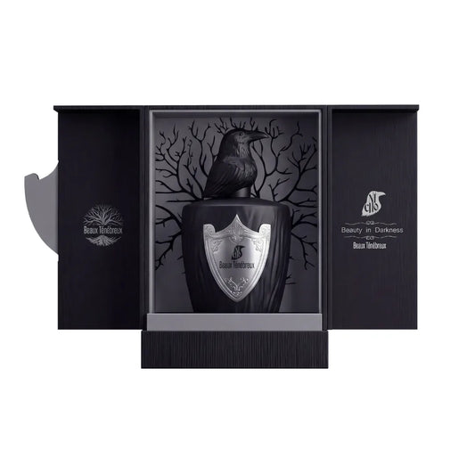 Estuche abierto de Beaux Ténébreux, El Nicho, con el frasco de tapón de cuervo sobre fondo gris con árbol y la frase Beauty in Darkness