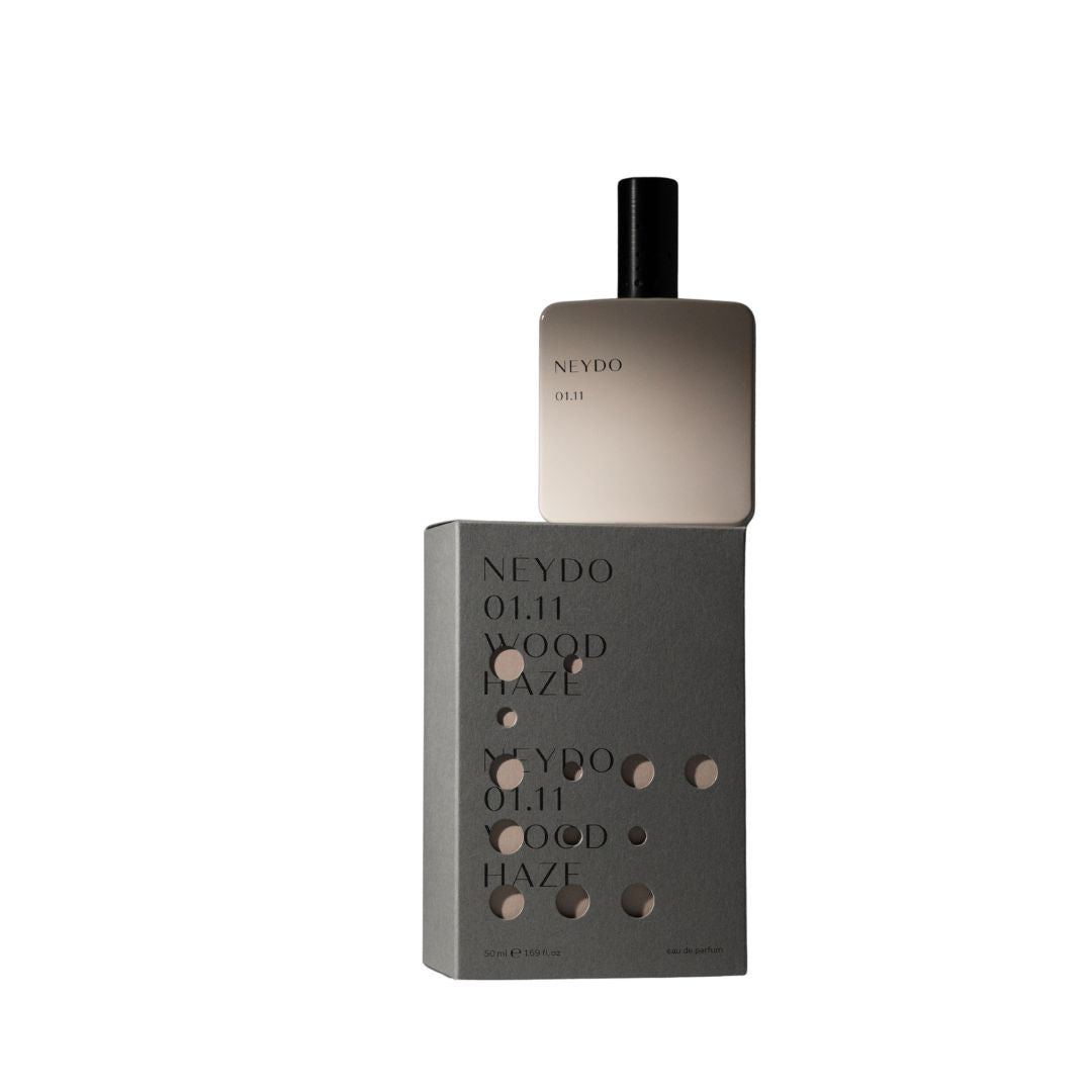 Perfume Neydo 01.11 en frasco beige sobre su caja, fragancia Wood Haze cálida y amaderada.