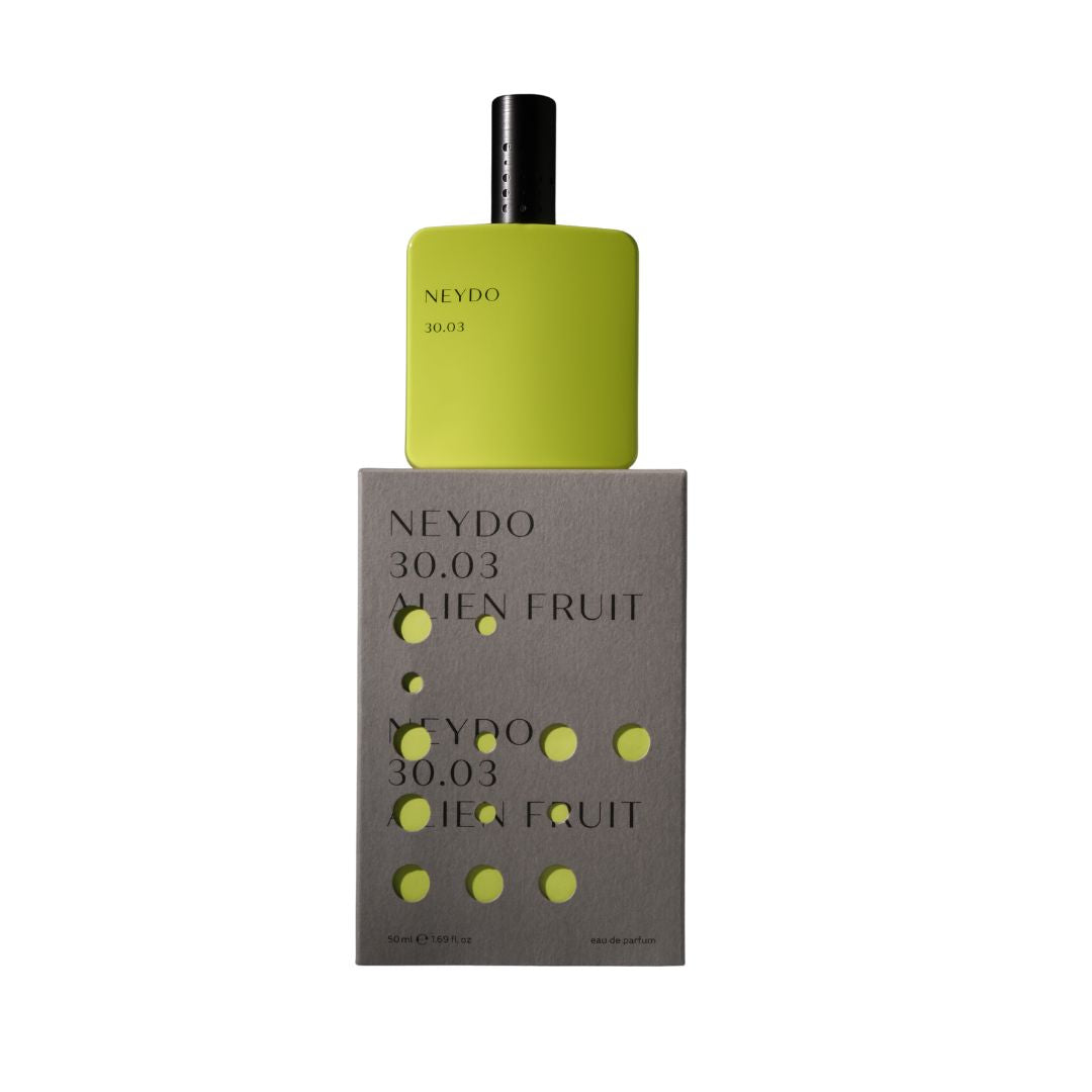 Perfume Neydo 30.03 en frasco amarillo sobre su caja, fragancia Alien Fruit exótica y cítrica.