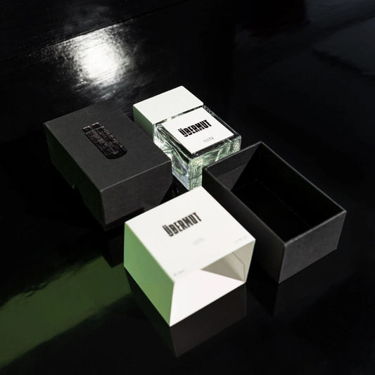 Estuche de Ubermut Parfum en tonos verdes junto al frasco, packaging Art Brut
