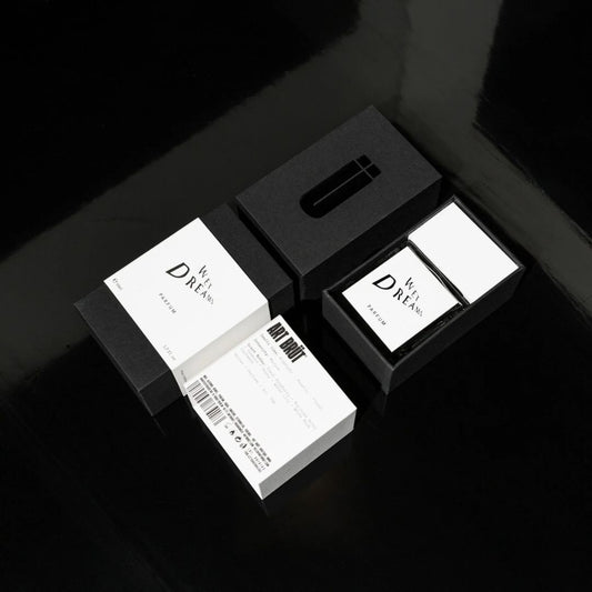 Estuche de Wet Dreams junto al frasco, packaging negro con ficha tecnica Art Brut