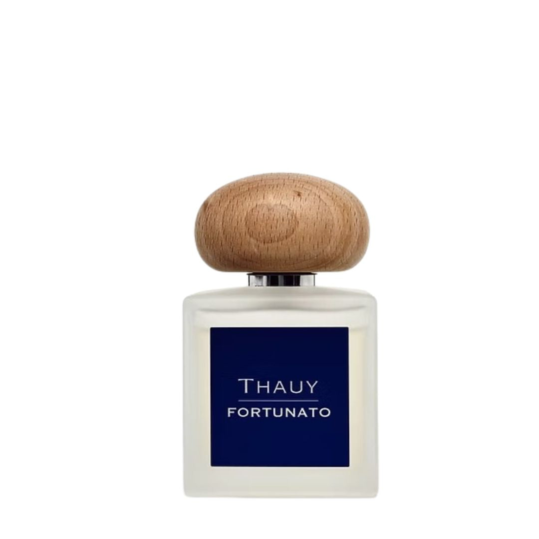 "Frasco del perfume Fortunato de THAUY con etiqueta azul y tapón de madera, aroma cítrico especiado unisex de la colección The Power of Resilience"