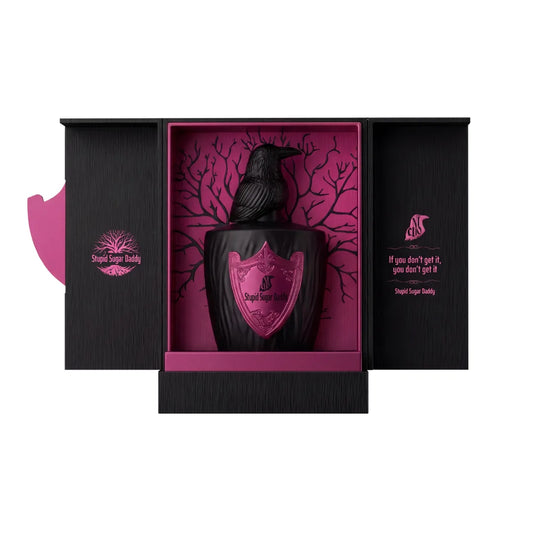 Estuche abierto de Stupid Sugar Daddy, El Nicho, con el frasco de tapón de cuervo sobre fondo fucsia con árbol y la frase If you don't get it, you don't get it